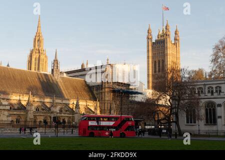 London, Greater London, England - Apr 24 2021: Parliament Square with a double decker bus in front of the Houses of Parliament. Stock Photo