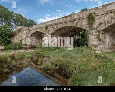 Puente de Orbigo reflecting in the river at Hospital de Orbigo, Spain, July 16, 2010 Stock Photo