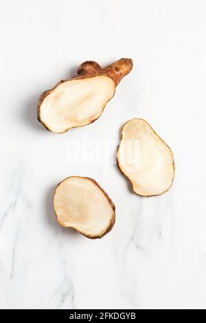 Overhead view of Jerusalem Artichokes on white marble Stock Photo