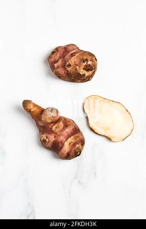 Overhead view of Jerusalem Artichokes on white marble Stock Photo