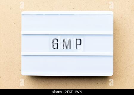 White lightbox with word  GMP (Abbreviation of good manufacturing practice) on wood background Stock Photo