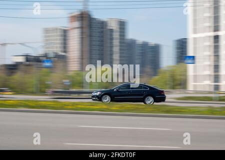 Ukraine, Kyiv - 20 April 2021: Blue Volkswagen Passat CC car moving on the street. Editorial Stock Photo