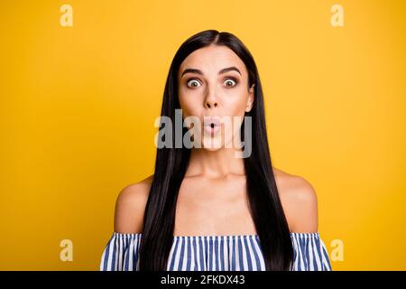 Photo of charming impressed young lady wear striped dress big eyes isolated yellow color background Stock Photo
