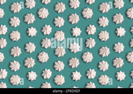 Seamless pattern texture with french meringue cookies on a green background Stock Photo