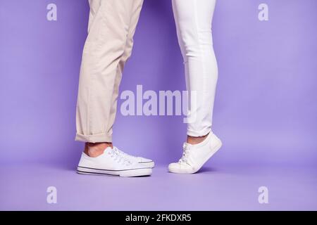 Cropped profile side photo of couple man and woman legs woman tip toes kiss isolated on purple color background Stock Photo