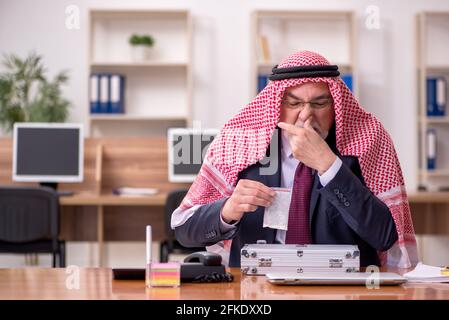 Aged arab employee selling narcotics at workplace Stock Photo