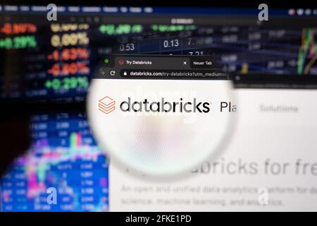 Databricks company logo on a website with blurry stock market developments in the background, seen on a computer screen through a magnifying glass Stock Photo