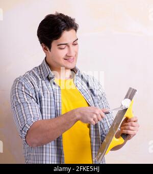 The young man applying plaster on wall at home Stock Photo