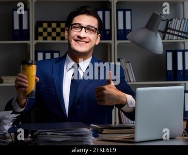 The employee working late and drinking strong coffee to stay awake Stock Photo