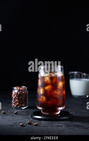 Iced Coffee in Tall Glass on Dark Background. Concept Refreshing Summer Drink. Stock Photo