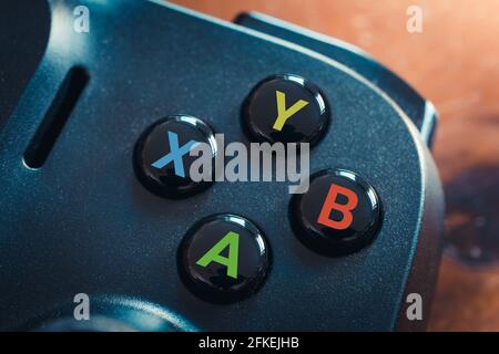Black Gaming Controller On Table With Focus On The 4 Action Buttons A, B, Y, X Stock Photo
