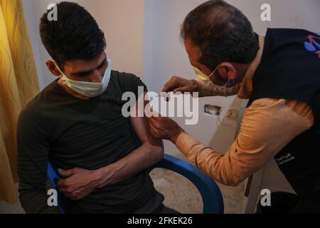 Idlib, Syria. 01st May, 2021. A member of the Syria Vaccine Team administers a dose of COVID-19 vaccine during the first phase of the vaccination campaign, aimed at medical and humanitarian workers, at Ibn Sina Hospital in Idlib. Credit: Anas Alkharboutli/dpa/Alamy Live News Stock Photo