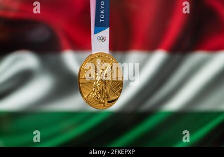 April 25, 2021 Tokyo, Japan. Gold medal of the XXXII Summer Olympic Games 2020 in Tokyo on the background of the flag of Hungary. Stock Photo