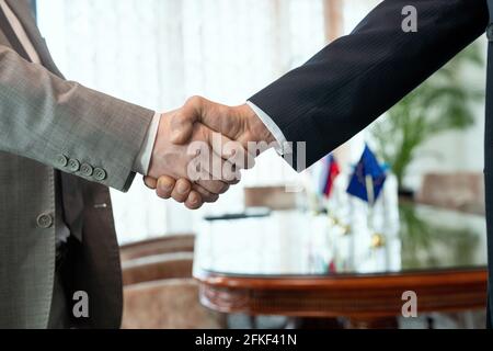 Two businessmen shaking hands after making deal in office Stock Photo