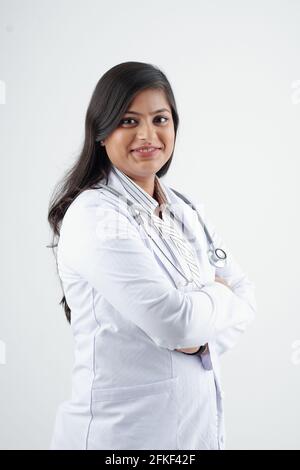 Smiling young Indian physician in labcoat crossing arms and lookig at camera Stock Photo