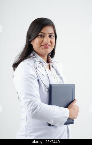 Portrait of young smiling female doctor in labcoat holding tablet computer and looking at camera Stock Photo