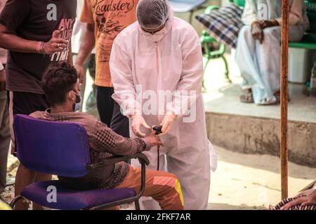 Ghaziabad, India. 01st May, 2021. A health worker checks the oxygen level of a covid-19 patient. India faces shortage of medical oxygen. In this situation NGO Khalsa Help International helps covid-19 patients who need oxygen, they serve free oxygen to them. In the last 24 hours, India recorded 401,993 new covid cases with 3,523 Deaths. Credit: SOPA Images Limited/Alamy Live News Stock Photo