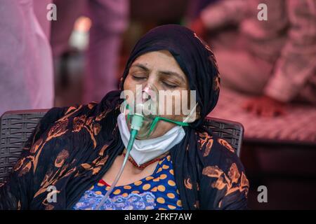 Ghaziabad, India. 01st May, 2021. A covid-19 patient wearing an oxygen mask receives free oxygen at Gurudwara. India faces shortage of medical oxygen. In this situation NGO Khalsa Help International helps covid-19 patients who need oxygen, they serve free oxygen to them. In the last 24 hours, India recorded 401,993 new covid cases with 3,523 Deaths. Credit: SOPA Images Limited/Alamy Live News Stock Photo