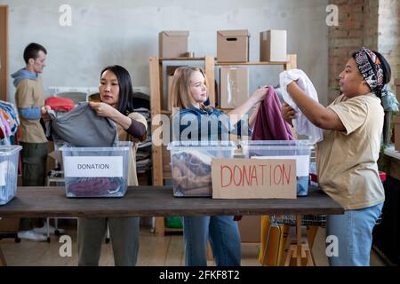 A group of people standing around a table with donation in boxes Stock Photo