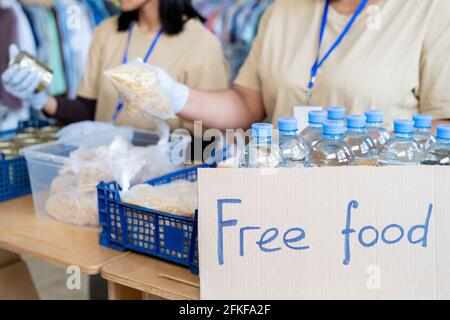 Volunteers serving free food and plastic bottles with water Stock Photo