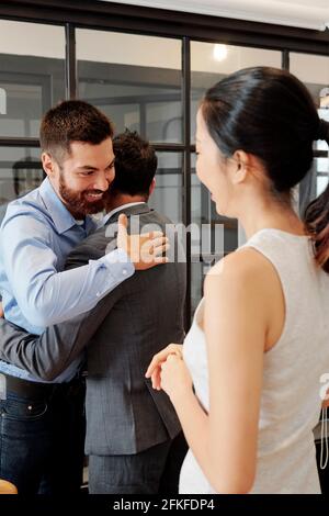Happy excited business people hugging after finishing work on big successful project Stock Photo