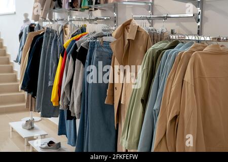 Stylish collection of women's clothing hanging on hangers in the showroom. Copspace Stock Photo