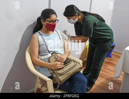 Mumbai, India. 01st May, 2021. A woman wearing a face mask gets a dose of Covishield vaccine at Bandra Kurla Complex (BKC) vaccination center in Mumbai. Vaccination drive for 18-44 years age group started on 1st May 2021. only those people who were eligible for the vaccine received confirmation about their registration on the phone. (Photo by Ashish Vaishnav/SOPA Images/Sipa USA) Credit: Sipa USA/Alamy Live News Stock Photo