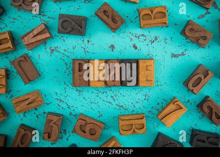 Peace Spelled in Wooden Type Set Block Letters on a Turquoise Background Stock Photo