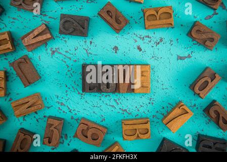 Love Spelled in Wooden Type Set Block Letters on a Turquoise Background Stock Photo