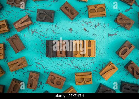 Faith Spelled in Wooden Type Set Block Letters on a Turquoise Background Stock Photo