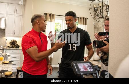 Lake Forest, USA. 01st May, 2021. German-American football player Amon-Ra St. Brown (l) hits one with his brother Equanimeous St. Brown, who already plays for the Green Bay Packers, after being selected in the NFL draft by the Detroit Lions. Credit: Maximilian Haupt/dpa/Alamy Live News Stock Photo