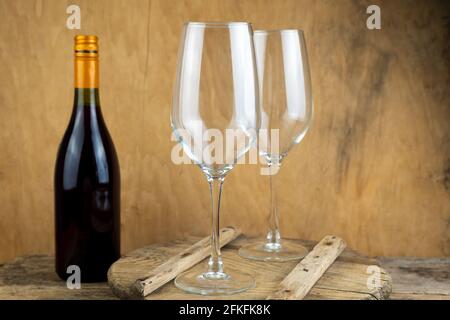 Two empty wine glasses and a bottle of wine are on the table. Romantic dinner. Drinking wine. Wineglass. Stock Photo