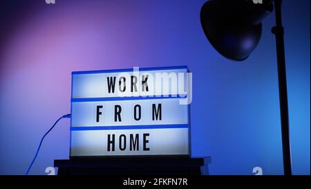 Work from home light box in studio. WFH Text on lightbox. Represent work from home for social distancing concept during coronavirus pandemic. WFH mess Stock Photo