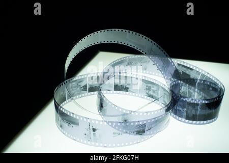 Analog black and white 35mm negative film strip on light tableoblique view with copy space, medium shot Stock Photo