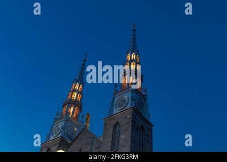 Gothic church spires lit up at night with a clear blue sky background Stock Photo