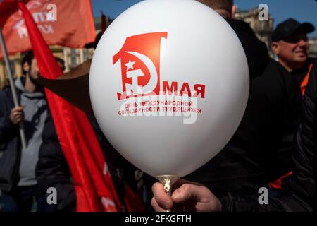 Moscow, Russia. 1st of May, 2021 Сommunists party supporters gather with balloons and red flags to mark Labour Day, also knows as May Day near Red Square in Moscow, Russia, The inscription on the ball reads 'The May 1st. The International Workers' Solidarity Day' Stock Photo