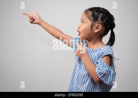 Portrait of Asian child and to collect hair and Put your index finger to air and make thinking excited pose on isolated white background, She is Happi Stock Photo