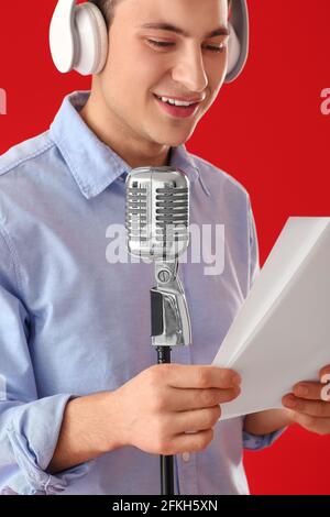 Male radio presenter with microphone on color background Stock Photo