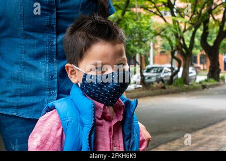 Medellin, Colombia - March 28 2021: Little Latin Boy Wearing a Blue Face Mask Outside Stock Photo