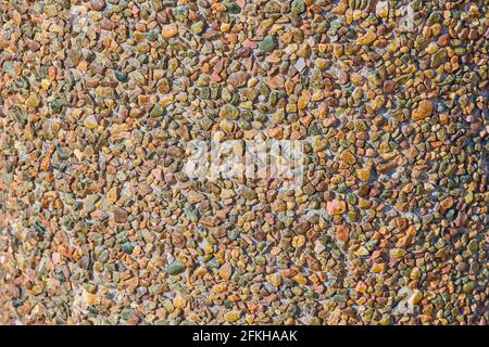 small multi-colored stones on the shore of the lake Stock Photo