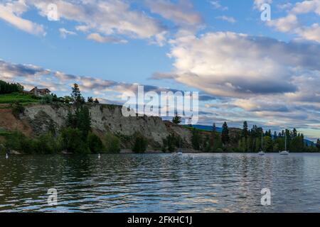 PENTICTON, CANADA - JULY 04, 2020: lake landscape with sailboats calm morning and house on the cliff Stock Photo