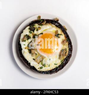 Stuffed portobello mushrooms with fried egg isolated on white background. Directly above. Stock Photo