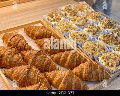 Fresh and puffy croissants and creamy cheese tarts in bakeshop  Stock Photo