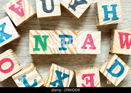 Alphabet letter block in word NPA (Abbreviation of Non performing assets or Nasopharyngeal airway) with another on wood background Stock Photo