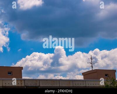 Cloud - towering cumulus - forming in the distance above the roof of the house Stock Photo
