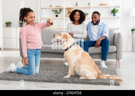 Black girl training and giving treat to her obedient dog Stock Photo