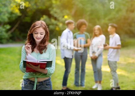 Cute Student Girl Holding Workbooks, Getting Ready For Lectures Outdoors At Campus Stock Photo