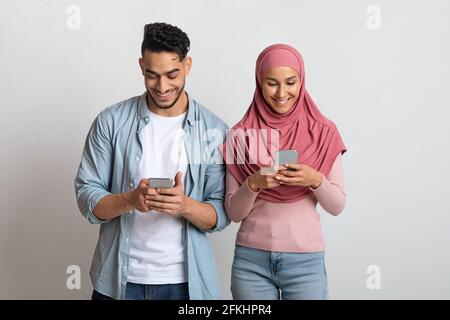 New App. Portrait Of Young Islamic Couple Using Smartphones Stock Photo