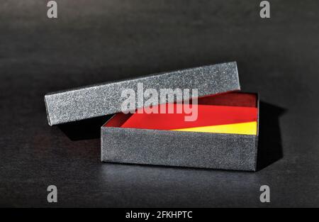 Opened empty black gift box on black background , black lid on box , Stock Photo