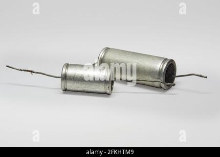 capacitors metal-paper with black flat ends. pair of vintage electronic parts of circuit of tube sound-amplifying equipment. with clipping path Stock Photo